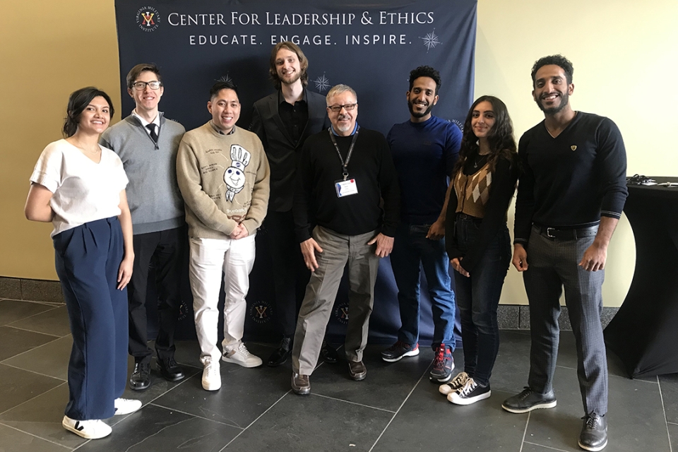 A group of people poses for a photo in front of a banner that reads "Center for leadership and ethics"