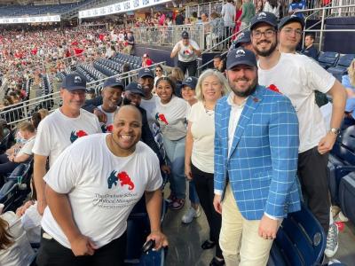Students in GSPM t-shirts smiling with Dean Riddle and President Granberg
