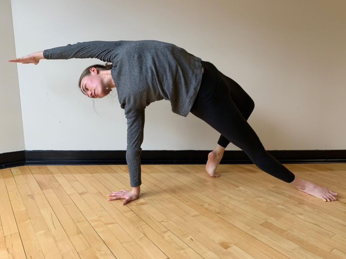 Woman in athletic clothing doing a side stretch yoga pose