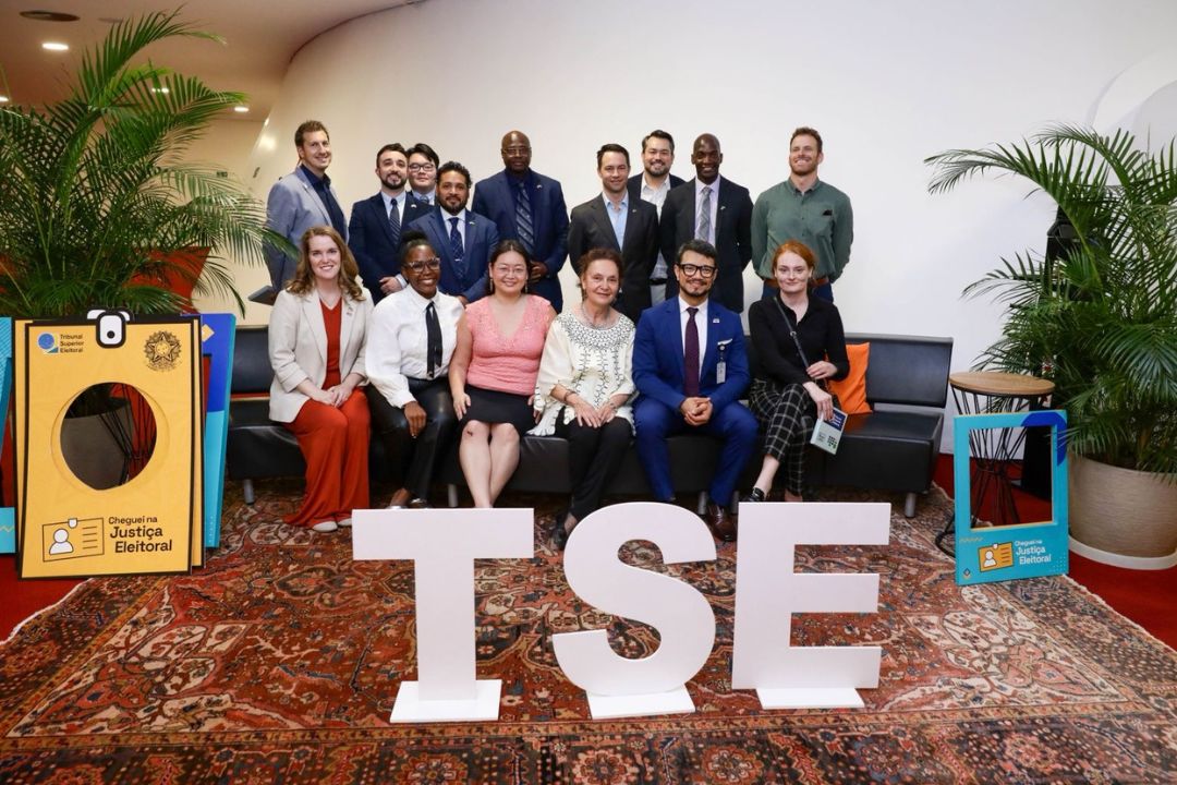 Group posed behind big white "TSE" letters