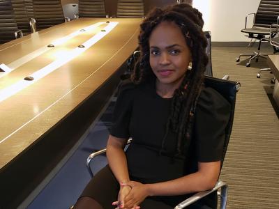 Alvine Ntandu, alumna in black dress in conference room