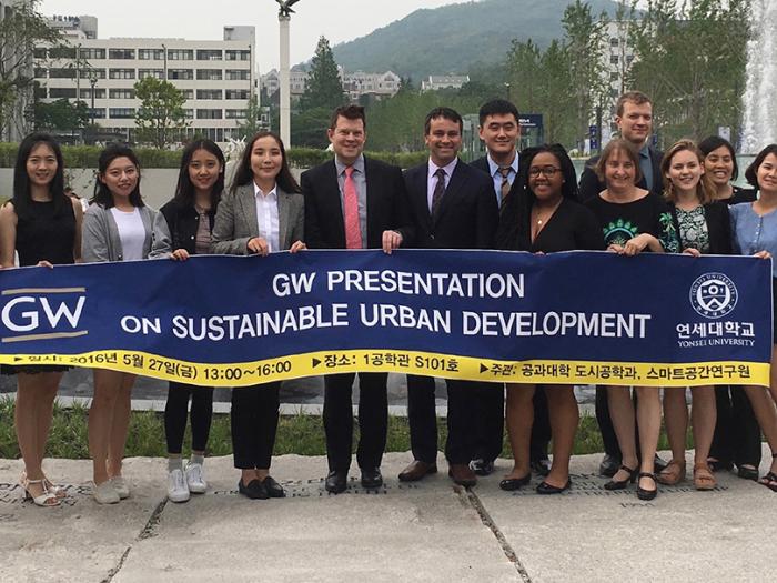 SUP student group with Program Director John Carruthers hold banner with words Sustainable Urban Planning Program, GW