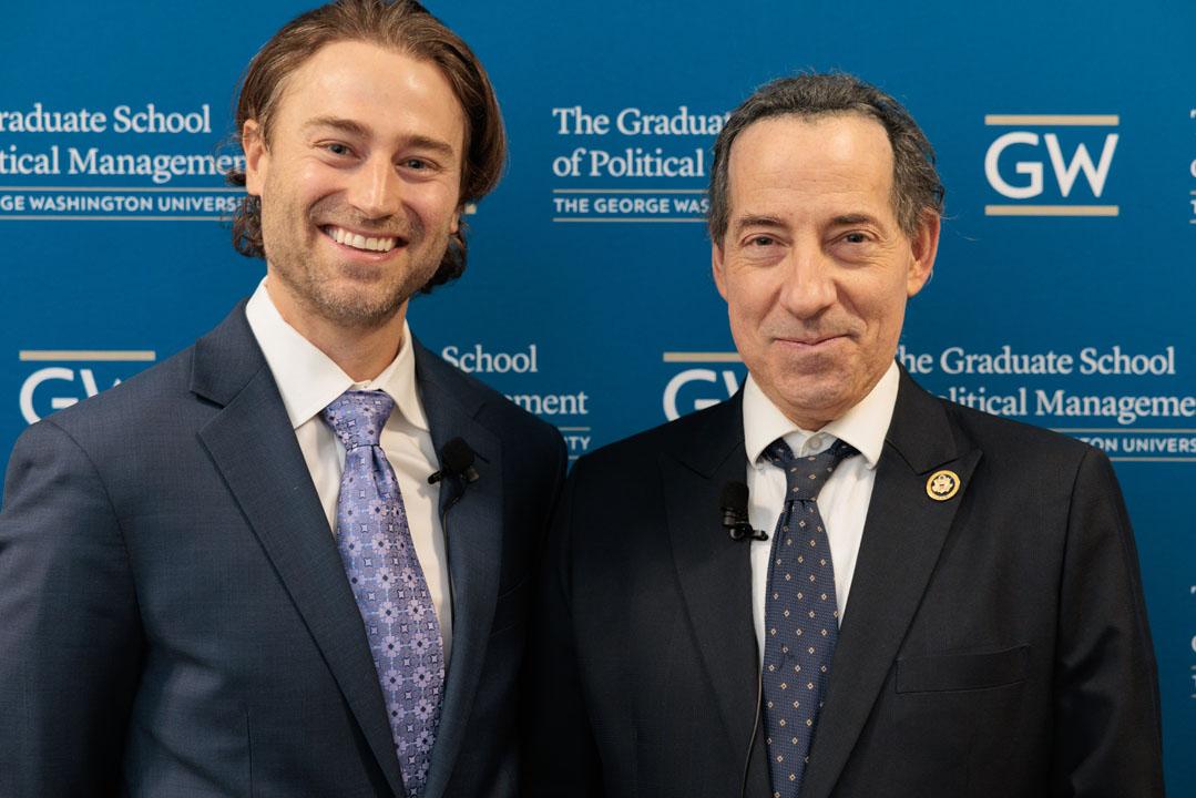 Casey Burgat and Jamie Raskin smiling in front of step-and-repeat