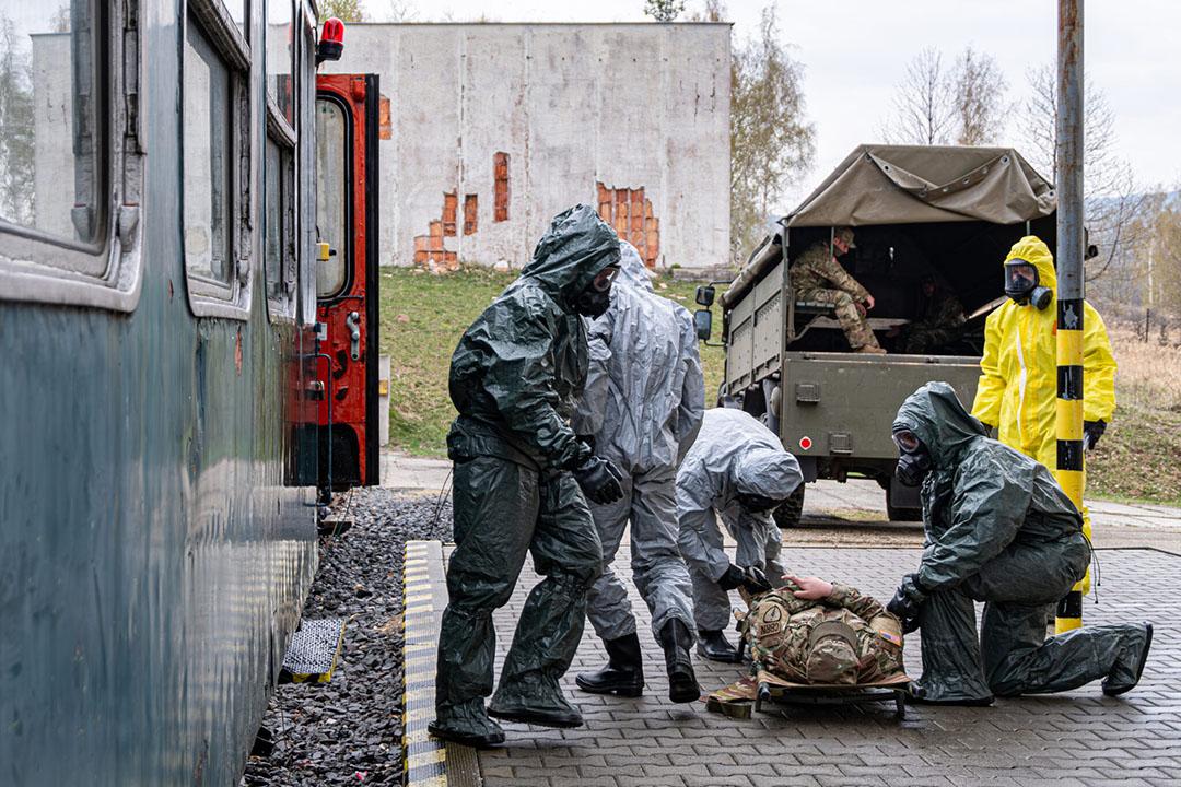emergency management simulation with 5 people working with a dummy wearing hazmat equipment